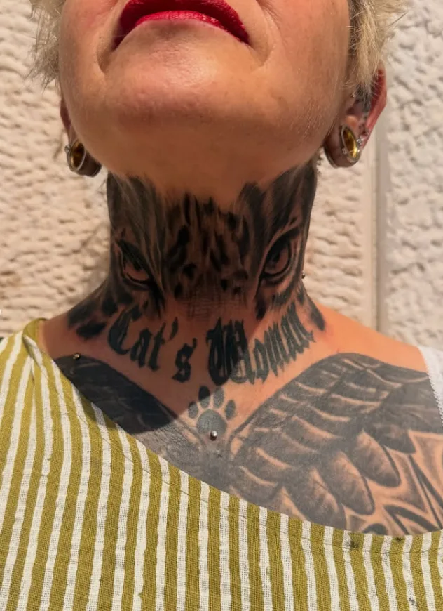 Olhar felino tatuado no pescoço